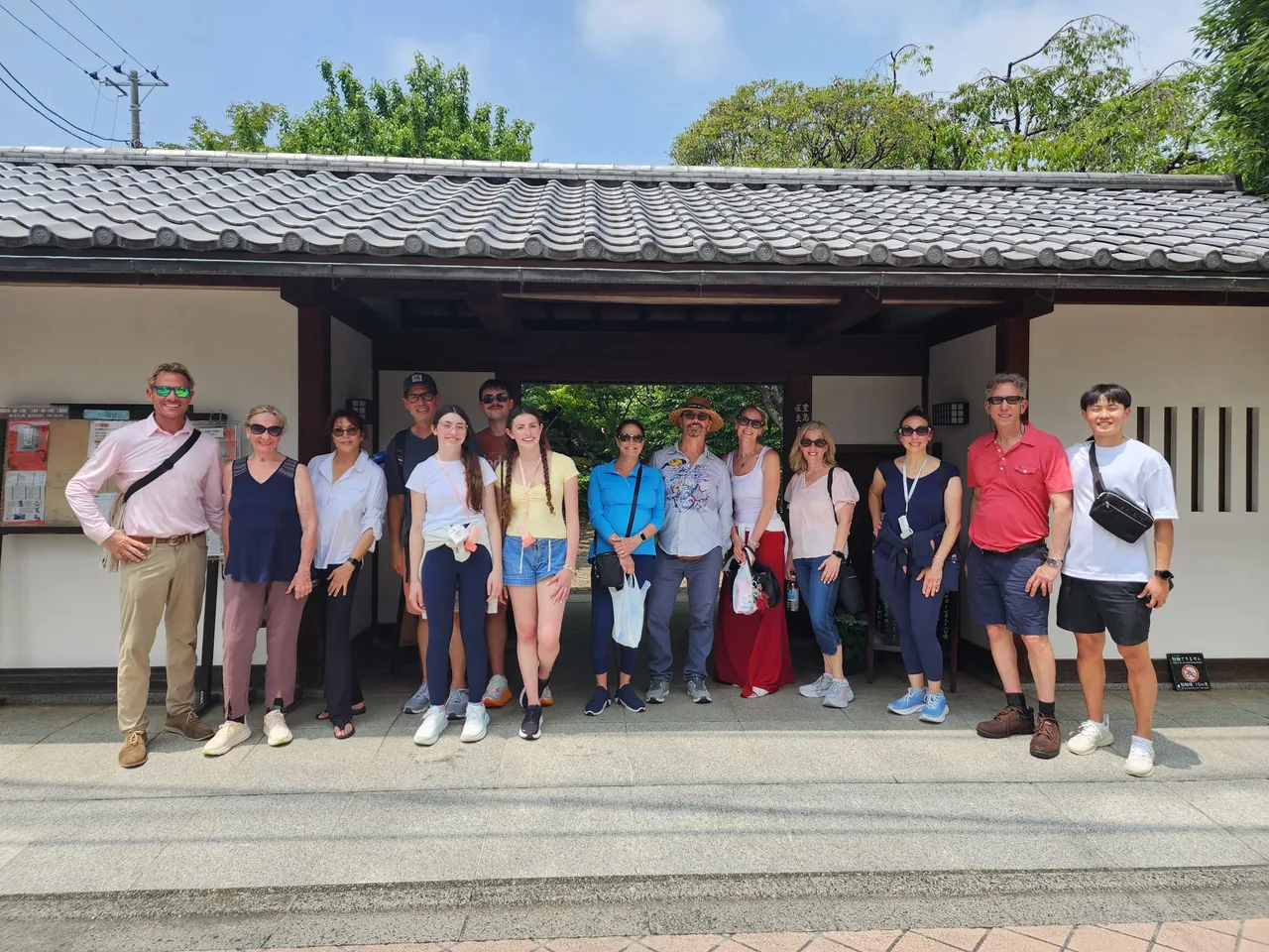 Tour guests standing beside a tiled-roof wall